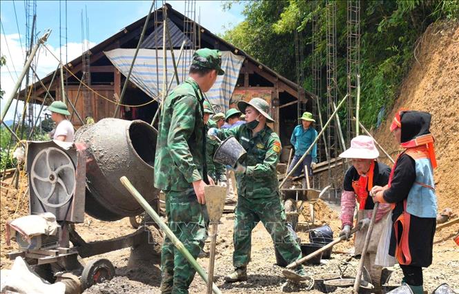 The border guards in the northern province of Lai Chau assist locals in building new houses. VNA/Photo by courtesy