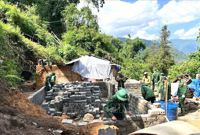 The border guards in the northern province of Lai Chau assist locals in building new houses. VNA/Photo by courtesy