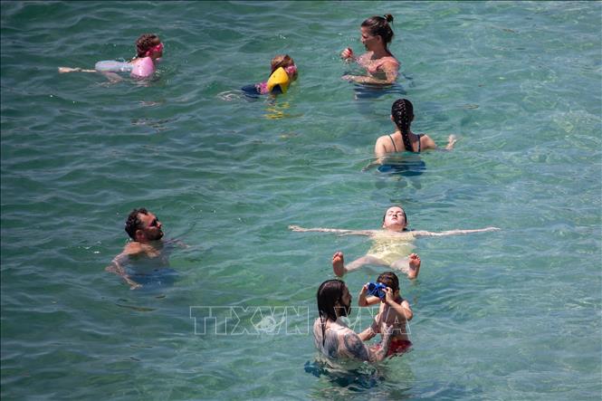 Người dân làm mát tại bãi biển ở Dubrovnik, Croatia khi làn sóng nhiệt đang bao trùm khu vực Balkan. Croatia, Bosnia và Serbia đã phải ban hành cảnh báo y tế do nắng nóng. Ảnh: THX/TTXVN 