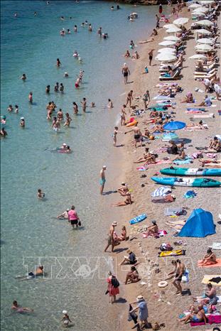 Người dân làm mát tại bãi biển ở Dubrovnik, Croatia khi làn sóng nhiệt đang bao trùm khu vực Balkan. Croatia, Bosnia và Serbia đã phải ban hành cảnh báo y tế do nắng nóng. Ảnh: THX/TTXVN 