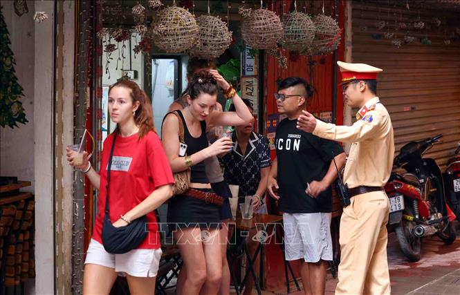 Lực lượng cảnh sát giao thông nhắc nhở các du khách rời khỏi khu vực hành lang đường sắt. Ảnh: Phạm Kiên - TTXVN