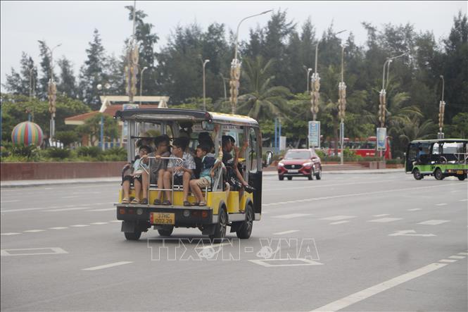 Du khách tham quan các điểm đến và dạo đường biển Cửa Lò bằng xe điện. Ảnh: Bích Huệ - TTXVN