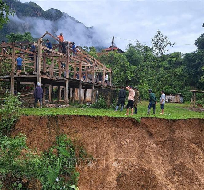 Tại xã Mường Chiên, tỉnh Sơn La, Công an xã và các lực lượng tại chỗ hỗ trợ người dân di dời nhà, tài sản ra khỏi khu vực có nguy cơ sạt lở do mưa lớn kéo dài. Ảnh: TTXVN phát