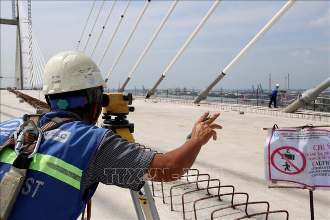 Đo cao độ trước khi thảm nhựa cầu Bình Khánh. Ảnh: Hồng Đạt - TTXVN
