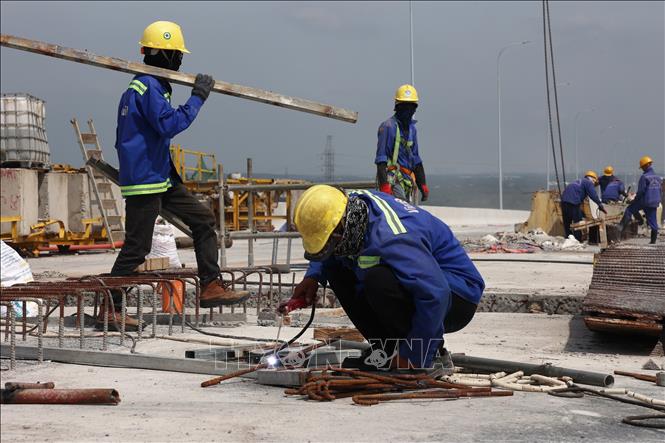 Công nhân thi công đồng loạt nhiều hạng mục hoàn thiện trên công trường cầu Bình Khánh. Ảnh: Hồng Đạt - TTXVN
