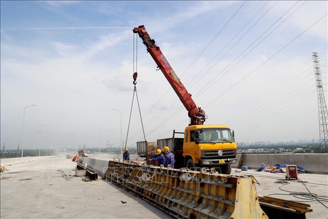 Thi công dải phân cách cầu Bình Khánh. Ảnh: Hồng Đạt - TTXVN
