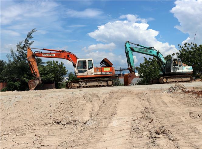 Không có mặt bằng sạch, máy móc được đưa đến thi công dự án thành phần 2 vẫn nằm phơi nắng. Ảnh: Công Thử - TTXVN