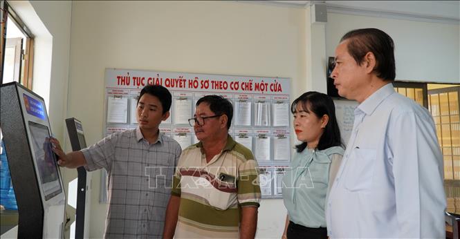 Cán bộ Trung tâm phục vụ hành chính công Đặc khu Kiên Hải hướng dẫn người dân đăng ký danh mục giải quyết hồ sơ. Ảnh: Văn Sĩ - TTXVN 