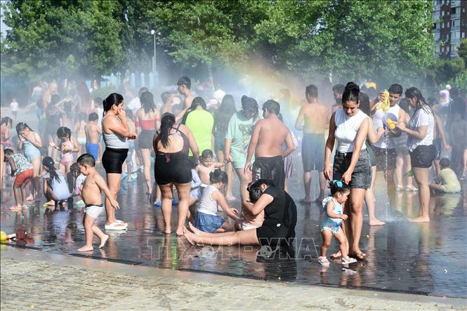 Người dân tránh nóng bên đài phun nước tại Madrid, Tây Ban Nha. Ảnh: THX/TTXVN