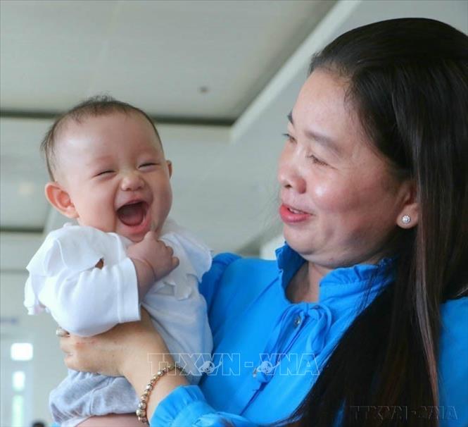 Bé gái theo mẹ nhận bằng khen tuyên dương gia đình tiêu biểu sinh đủ 2 con một bề là gái do tỉnh Hậu Giang tổ chức (5/1/2023). Ảnh: Duy Khương - TTXVN