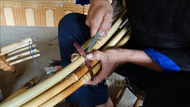 Công đoạn người Mông thắt nút cây khèn. Ảnh: Tuấn Anh - TTXVN                             