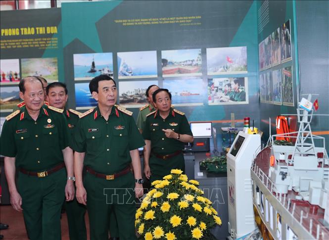 Đại tướng Phan Văn Giang, Ủy viên Bộ Chính trị, Phó Bí thư Quân ủy Trung ương, Bộ trưởng Bộ Quốc phòng và các đại biểu tham quan gian trưng bày sản phẩm của các đơn vị Quốc phòng. Ảnh: Trọng Đức - TTXVN