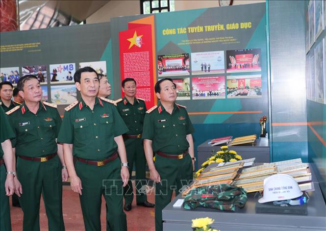 Đại tướng Phan Văn Giang, Ủy viên Bộ Chính trị, Phó Bí thư Quân ủy Trung ương, Bộ trưởng Bộ Quốc phòng và các đại biểu tham quan gian trưng bày sản phẩm của các đơn vị Quốc phòng. Ảnh: Trọng Đức - TTXVN