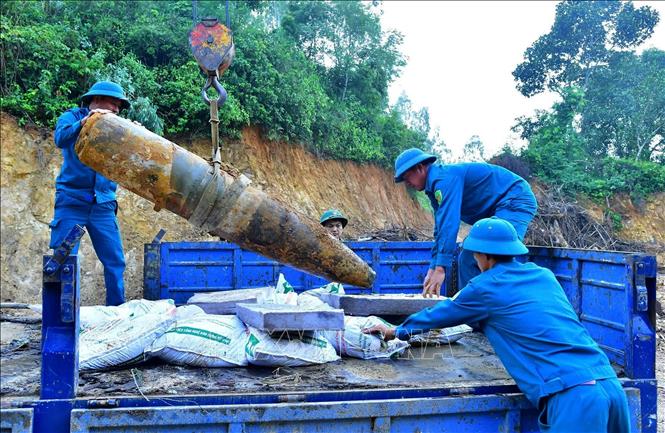 Lực lượng chức năng di dời quả bom đến nơi hủy nổ. Ảnh: TTXVN phát