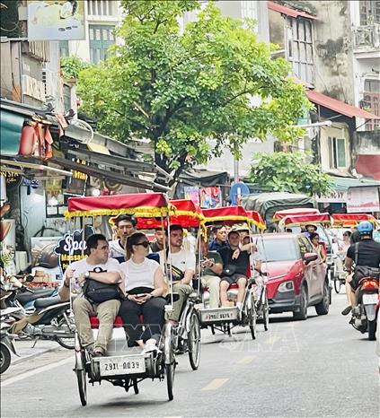 Khách du lịch đi xích lô ngắm phố cổ Hà Nội. Ảnh: Tuyết Mai - TTXVN
