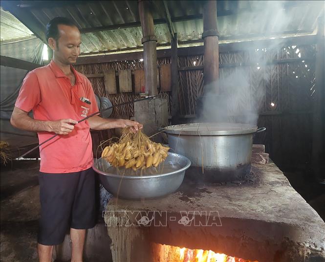 Các thế hệ gia đình Huỳnh Văn Tư lưu giữ nghề làm bánh dừa Giồng Luông truyền thống tồn tại hơn trăm năm của gia đình. Ảnh: Chương Đài  - TTXVN 