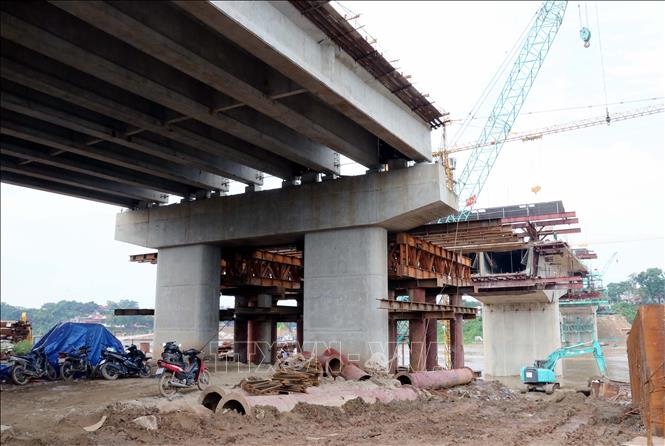Các đơn vị thi công huy động nhiều nhân lực và thiết bị máy móc đẩy nhanh tiến độ thi công cầu. Ảnh: Tạ Toàn – TTXVN