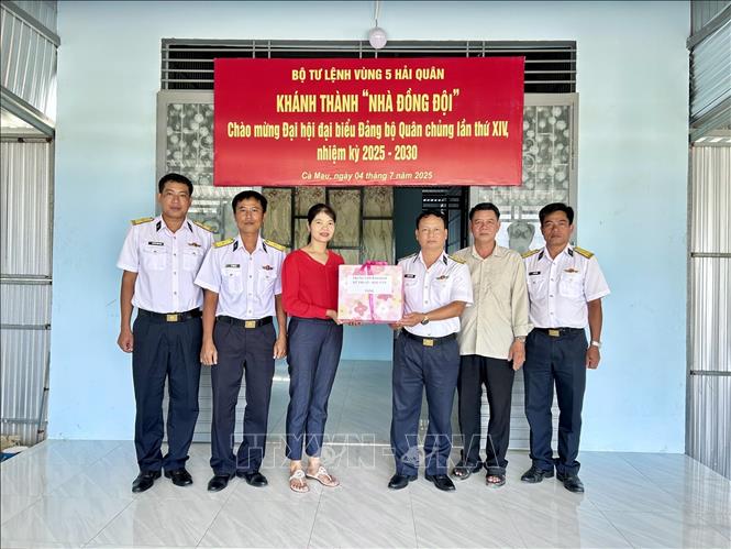 Thượng tá Phạm Khắc Đông, Chính ủy Trung tâm Bảo đảm Kỹ thuật – Hậu cần tặng quà động viên gia đình quân nhân trong dịp khánh thành nhà mới. Ảnh: TTXVN phát