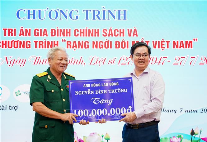 Anh hùng lao động Nguyễn Đình Trường (trái) trao tặng 100 triệu đồng thực hiện chương trình “Rạng ngời đôi mắt Việt Nam” nhằm tri ân gia đình chính sách, người có công với cách mạng. Ảnh: Giang Phương – TTXVN