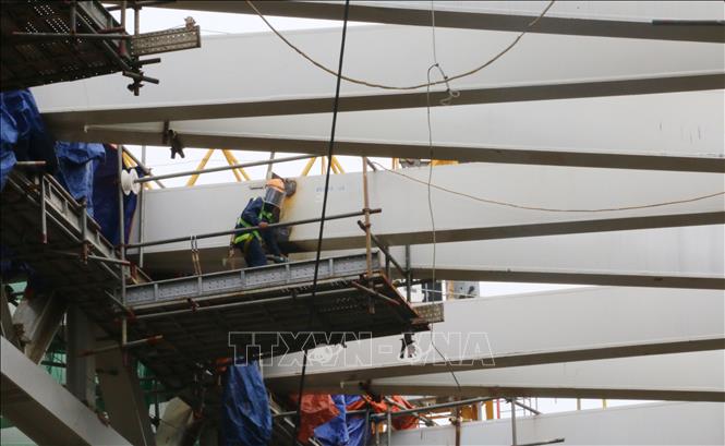 Công nhân làm những công đoạn cuối cùng tại đỉnh mái nhà ga sân bay Long Thành. Ảnh: Công Phong - TTXVN
