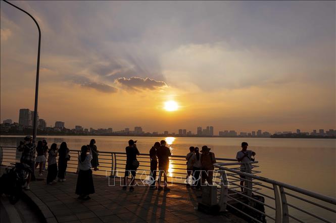 Nhiều người dân lưu lại khoảnh khắc với vẻ đẹp của hoàng hôn Hồ Tây. Ảnh: Khánh Hòa - TTXVN
