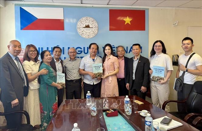 Dịch giả Nguyễn Quyết Tiến ( thứ 6 từ trái sang) trao tặng Trung tâm bộ sách từ điển và hội thoại Việt – Séc – Anh do chính ông biên soạn, đồng thời cam kết dịch miễn phí các tác phẩm thơ tiếng Việt sang tiếng Séc để phục vụ công tác giảng dạy. Ảnh: Việt Thắng - PV TTXVN tại Séc