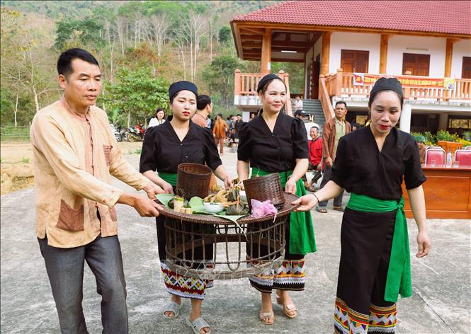 Người dân Ơ Đu di chuyển các mâm cúng (cúng thần Sấm, cúng làm vía cho dân bản) ra địa điểm cúng được thực hiện ngoài trời ngay trung tâm bản Văng Môn (xã Nga My, Nghệ An). Ảnh: Xuân Tiến - TTXVN 
