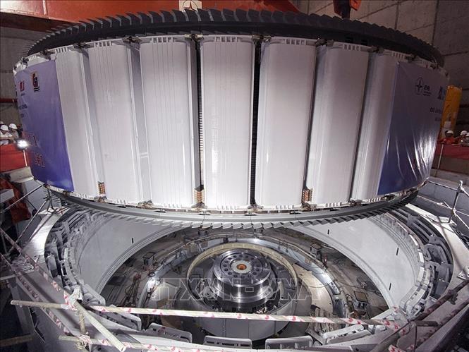 Rotor của tổ máy số 1 có trọng lượng khoảng 585 tấn, là phần quay của máy phát điện, công tác hạ đặt rotor vào stator đòi hỏi độ chính xác kỹ thuật rất cao và là một trong những bước quan trọng trong toàn bộ quá trình lắp đặt tổ máy. Ảnh: Vũ Sinh - TTXVN