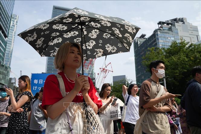 Người dân di chuyển trên đường phố dưới trời nắng nóng tại Tokyo, Nhật Bản. Ảnh: THX/TTXVN