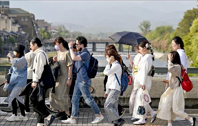 Người dân di chuyển trên đường phố dưới trời nắng nóng tại Kyoto, Nhật Bản. Ảnh: Kyodo/TTXVN