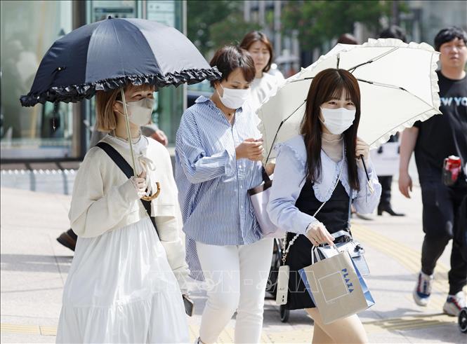 Người dân di chuyển trên đường phố dưới trời nắng nóng tại Fukuoka, Nhật Bản. Ảnh: Kyodo/TTXVN