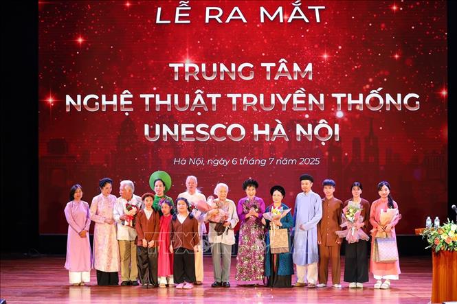 Ban lãnh đạo Trung tâm Nghệ thuật Truyền thống UNESCO Hà Nội chụp ảnh cùng các nghệ sĩ gạo cội và thế hệ trẻ. Ảnh: Khánh Hoà - TTXVN