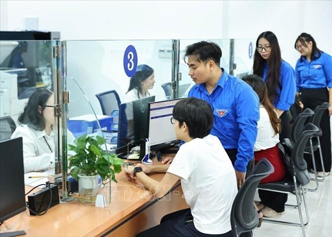 Đội thanh niên tình nguyện hỗ trợ vận hành chính quyền 2 cấp và cung cấp dịch vụ công trực tuyến tại Trung tâm Phục vụ Hành chính công phường Cầu Giấy, Hà Nội. Ảnh: Minh Đức - TTXVN