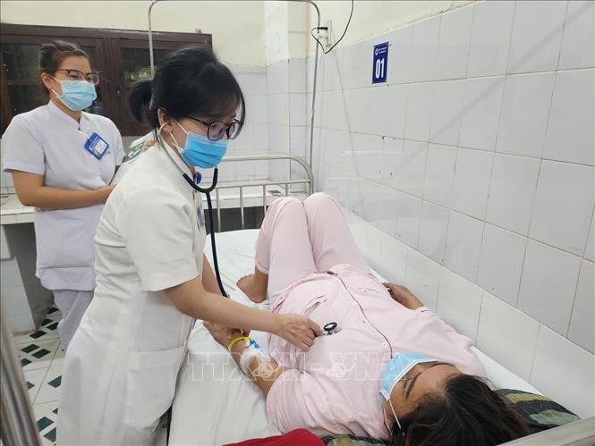 Bác sĩ, điều dưỡng Khoa Bệnh nhiệt đới, Bệnh viện Trung ương Huế kiểm tra, theo dõi sức khỏe bệnh nhân mắc liên cầu lợn. Ảnh: Mai Trang - TTXVN