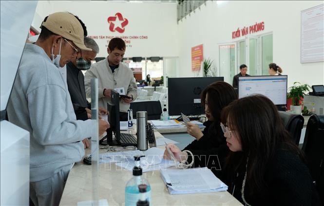 Cán bộ Trung tâm phục vụ hành chính công tỉnh Lâm Đồng hướng dẫn người dân đến làm thủ tục hành chính tại đơn vị. Ảnh: Nguyễn Dũng – TTXVN 