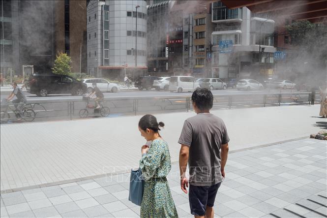 Phun sương để giảm nhiệt trên đường phố tại Tokyo, Nhật Bản. Ảnh: THX/TTXVN