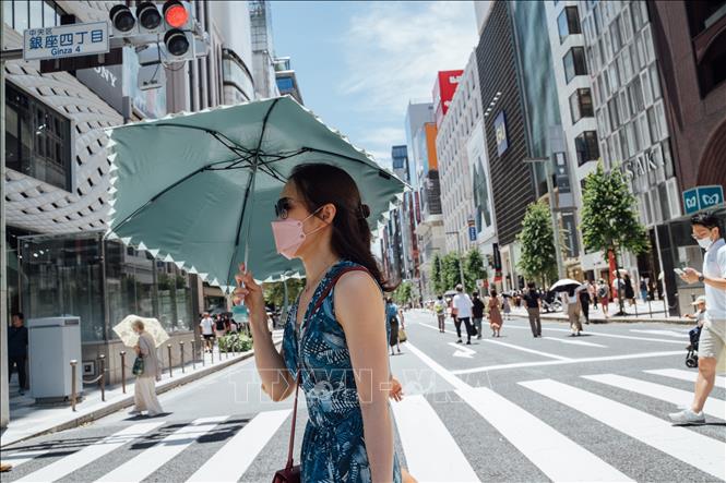 Người dân di chuyển trên đường phố dưới trời nắng nóng tại Tokyo, Nhật Bản. Ảnh: THX/TTXVN