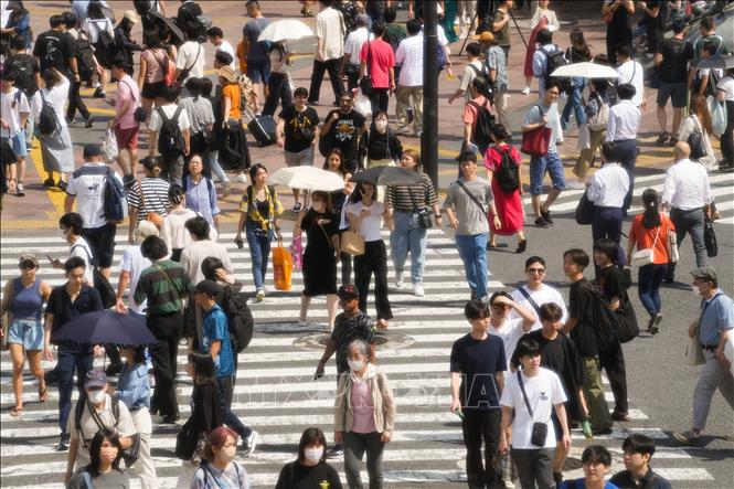 Người dân di chuyển trên đường phố dưới trời nắng nóng tại Tokyo, Nhật Bản. Ảnh: THX/TTXVN