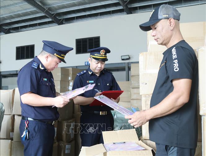 Cán bộ Hải quan Cửa khẩu Tân Thanh (Lạng Sơn) kiểm tra thực tế mẫu mã, chủng loại hàng hóa mở tờ khai tại cửa khẩu. Ảnh: Quang Duy – TTXVN