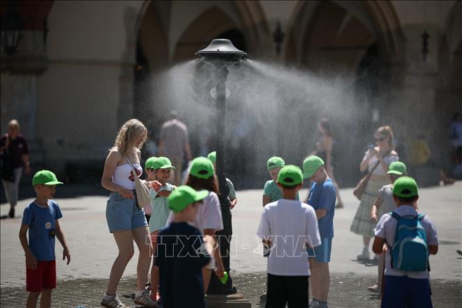 Phun hơi nước làm mát trong ngày nắng nóng tại Krakow, Ba Lan. Ảnh: PAP/TTXVN
