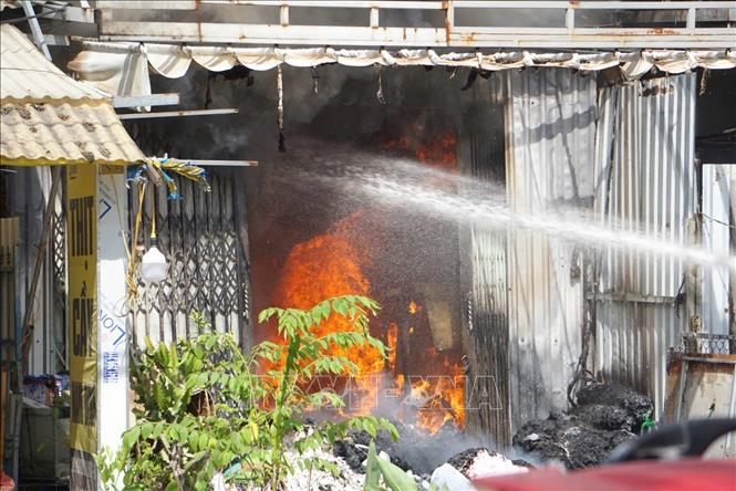 Lực lượng chức năng khống chế đám cháy tại nhà kho chứa vải ở phường An Khê, thành phố Đà Nẵng. Ảnh: TTXVN phát