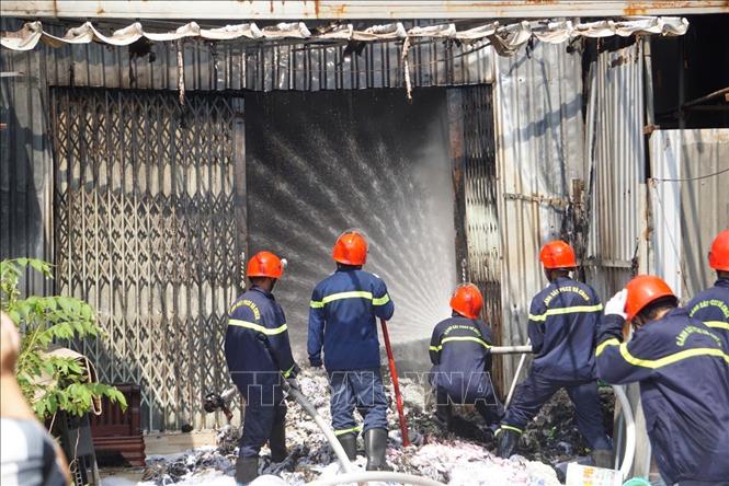 Lực lượng chức năng khống chế đám cháy tại nhà kho chứa vải ở phường An Khê, thành phố Đà Nẵng. Ảnh: Khoa Chương - TTXVN