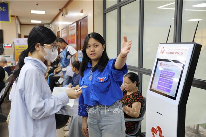 Thanh niên tình nguyện hướng dẫn, hỗ trợ người dân thực hiện thủ tục hành chính tại phường Bạch Mai. Ảnh: Quốc Lũy - TTXVN
