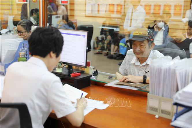 Cán bộ tại Điểm tiếp nhận, phục vụ hành chính công  phường Bạch Mai tiếp nhận và xử lý thủ tục hành chính cho người dân. Ảnh: Quốc Lũy - TTXVN