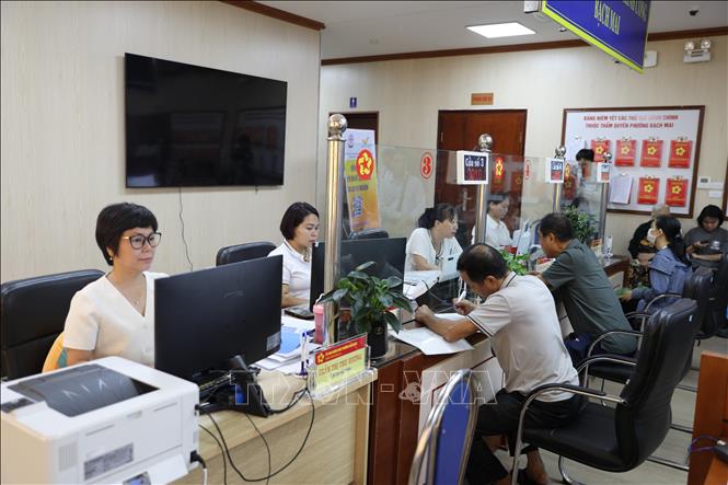 Cán bộ giải quyết thủ tục hành chính công cho người dân tại phường Bạch Mai. Ảnh: Quốc Lũy - TTXVN