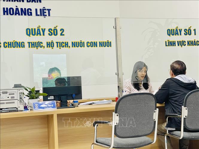 Cán Cán bộ phường Hoàng Liệt (Hà Nội) tận tình hướng dẫn người dân làm thủ tục hành chính Ảnh: Tuyết Mai - TTXVN