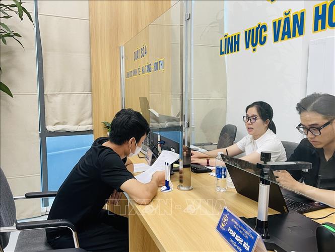 Cán bộ phường Hoàng Liệt (Hà Nội) hướng dẫn người dân thủ tục hành chính Ảnh: Tuyết Mai - TTXVN