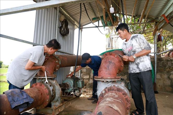 Công nhân Trạm thủy nông kênh chính Bắc Đồng Cam, tỉnh Đắk Lắk lắp đặt máy bơm để chống hạn. Ảnh: Xuân Triệu - TTXVN