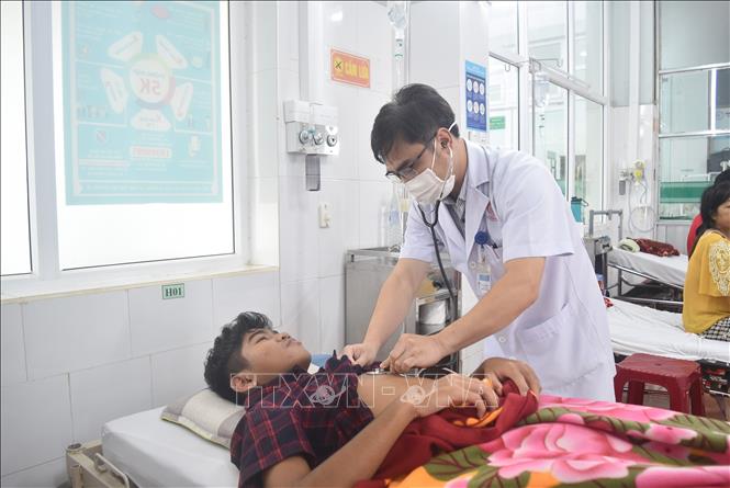 Bác sỹ thăm khám cho bệnh nhân bị sốt xuất huyết. Ảnh: Nguyên Dung – TTXVN