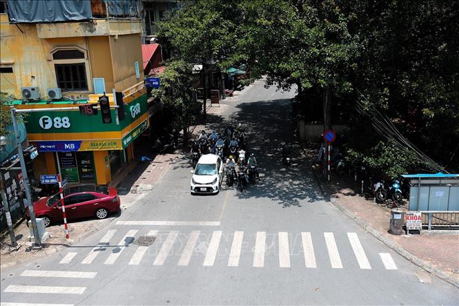 Nhiều phương tiện tham gia giao thông đỗ vào nơi có bóng mát trên đường Nguyễn Ngọc Vũ để dừng đèn đỏ. Ảnh: Lê Đông - TTXVN